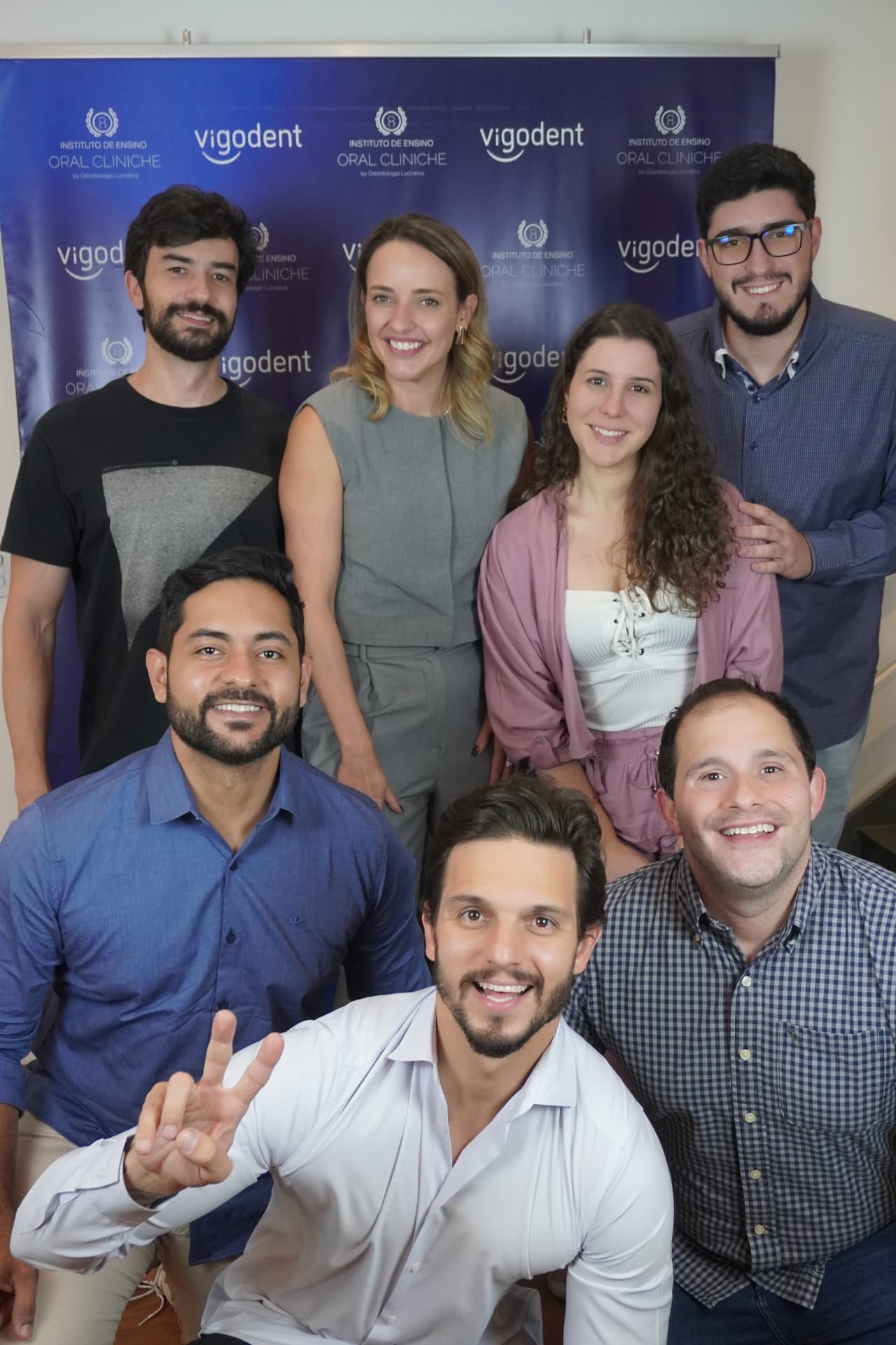 Dentistas formados na imersão posando com o banner do Instituto Oral Cliniche